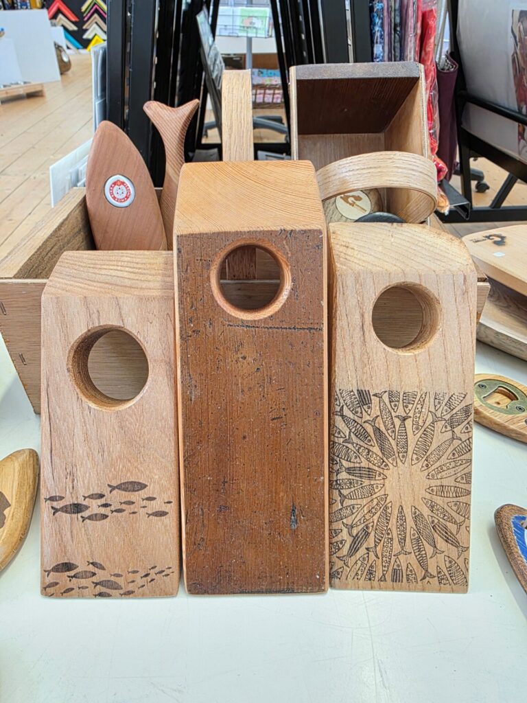 Three wooden wine bottle gravity stands, centre stand made from antique Castel Church pine, others with fish designs